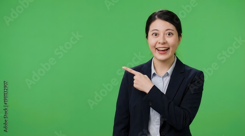 Asian businesswoman pointing to side, green screen background, presenting idea