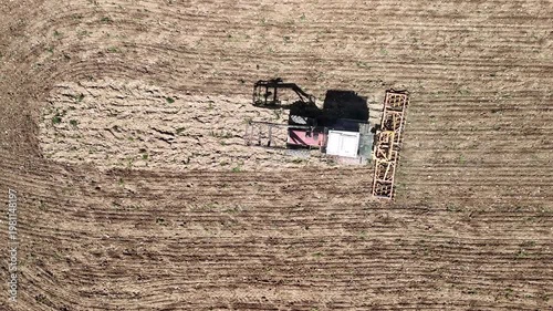 Aerial Drone View of Tractor Plowing Agricultural Field with Patterned Farmland