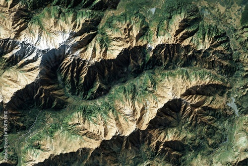 Detailed aerial satellite view of rugged mountain range with deep valleys and arid terrain