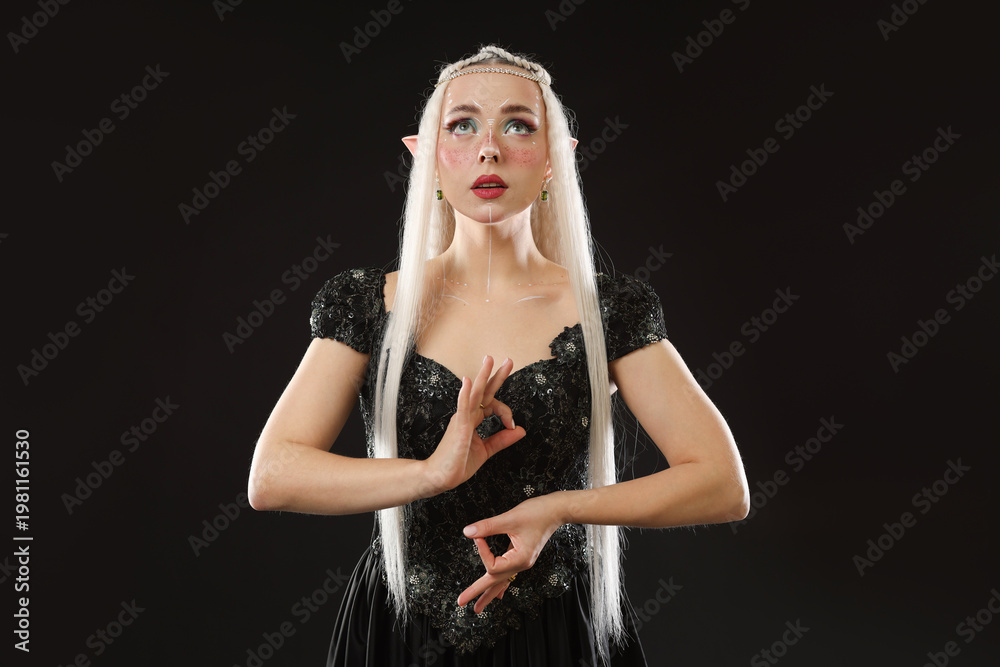 Fototapeta premium Beautiful girl dressed as elf on black background
