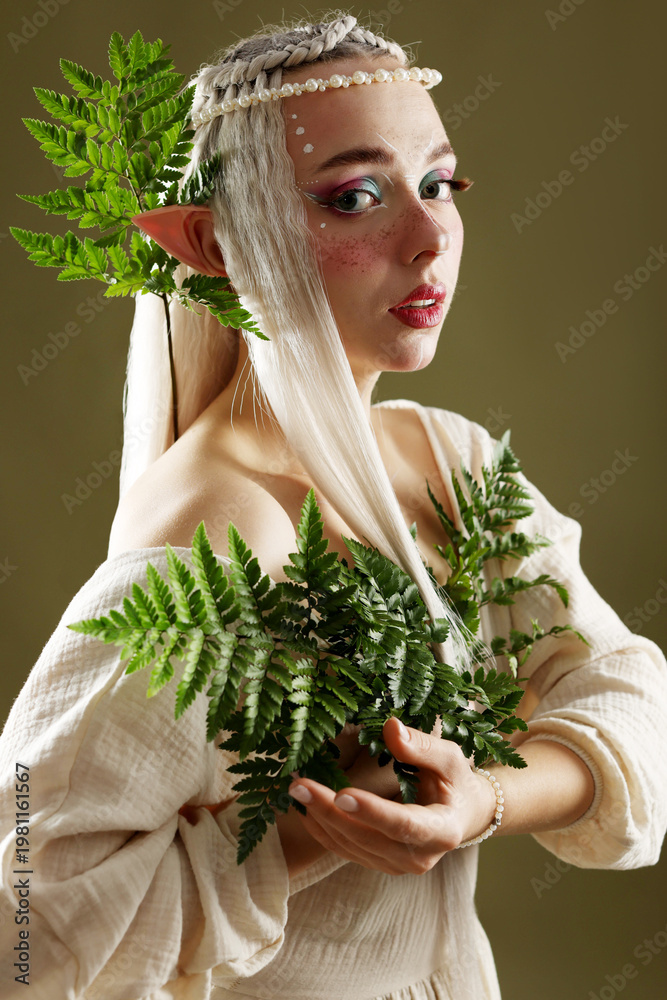 Fototapeta premium Beautiful elf girl with floral decor on dark olive background