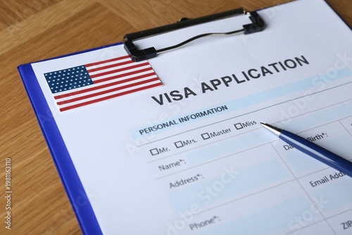Cuadro en lienzo Visa application form for immigration to American flag and pen on table, closeup