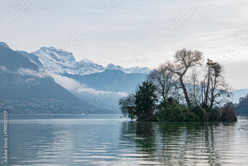 landscape of Lac d´Annecy in France with mountains in background and an island with trees in the middle of the lake