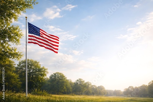 An American flag waving in a serene landscape with trees and a blue sky