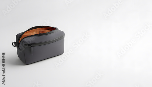 Dark gray travel toiletry bag with orange lining and minimalist modern design