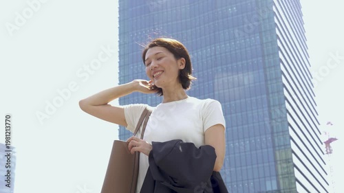 Cheerful Japanese Businesswoman Smiling Outdoors on Sunny Day, Low Angle, Commuting to Work, Summer
