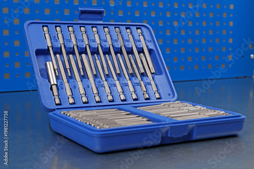 A set of metal bits for installation work in a plastic case.