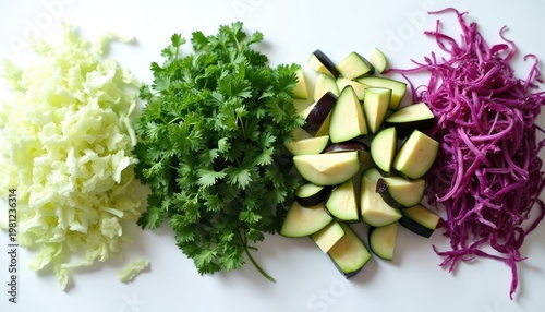Freshly cut vegetables, herbs arranged on white surface. Shredded white cabbage, parsley bunch, chopped eggplant slices, red cabbage shreds displayed from above. Healthy ingredients for cooking salad