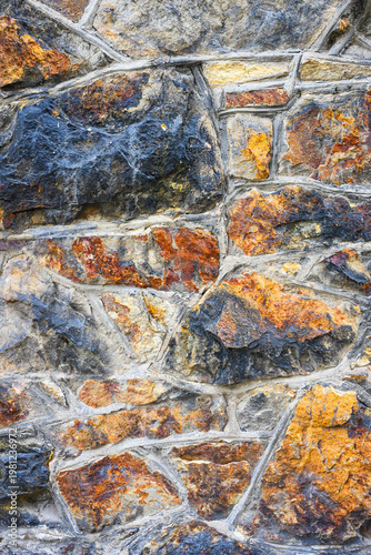 Background texture of constructed stone wall using large natural colored rocks