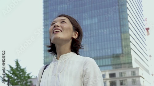 Japanese Woman Looking Up and Smiling Outdoors, Fulfilled and Relaxed, Mental Wellness, Urban