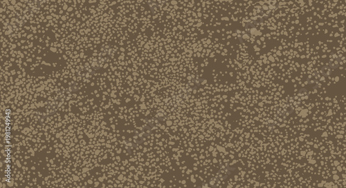 A close-up view of a rough, granular brown texture with scattered lighter specks, resembling sand or soil.