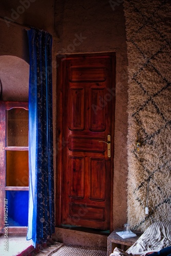 Traditional Moroccan room with wooden door and rug wall