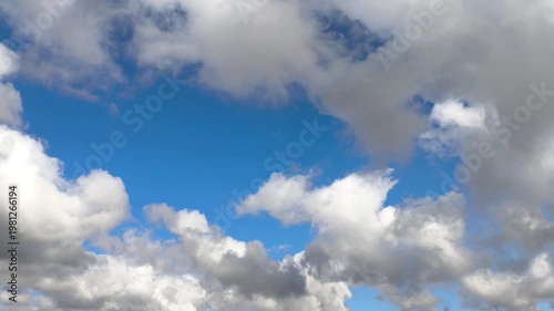 Darker cumulus clouds are moving in the blue sky