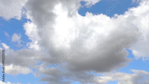 Enormous shadowed and briliant cloud moving in the blue sky
