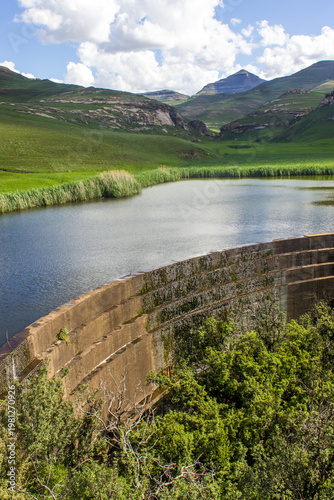 Picturesque view of the overflow at the dam wall of a small reservoir nestled in the Drakensberg Mountains in the Golden Gate Highlands National Park of South Africa
