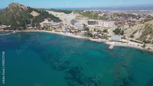 Top view of turquoise tropical sea and construction site on shore.
