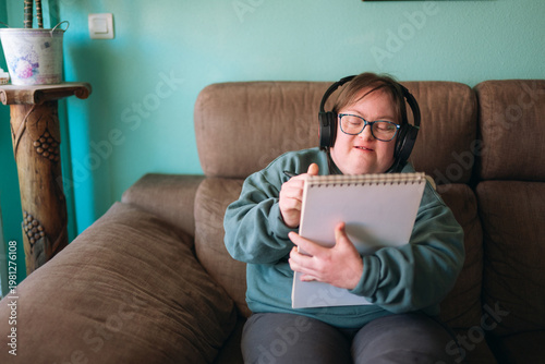 Young woman with down syndrome drawing and listening music