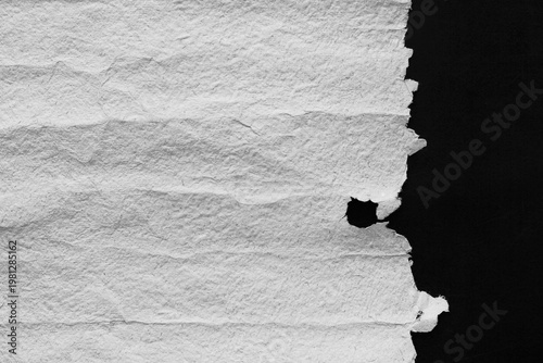 Rough handmade paper texture with visible folds and torn edges on black background, natural recycled surface background for vintage design, craft projects, organic branding and stationery layouts