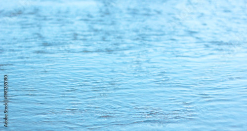 Abstract blue sea water surface texture background with soft ripples and gentle waves, minimal ocean pattern for design, calm summer nature backdrop with copy space