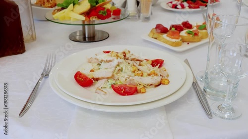 Gourmet caesar salad featuring grilled chicken, ripe cherry tomatoes on pristine white linen, highlighting sophisticated culinary presentation for special occasion