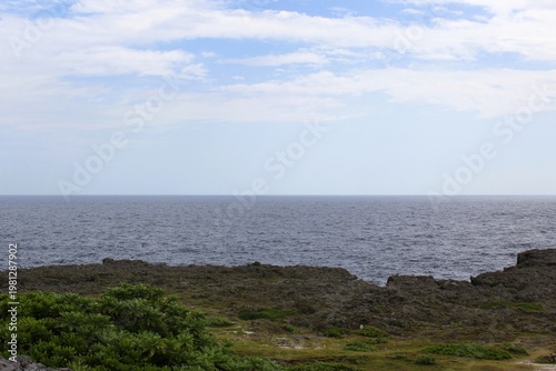 Rugged cliffs meet the ocean under a cloudy sky in Hateruma Island