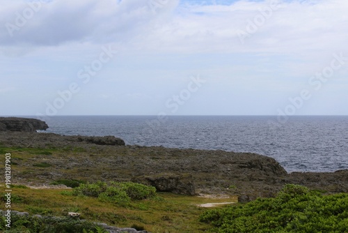 Rugged cliffs meet the ocean under a cloudy sky in Hateruma Island