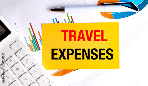 Travel expenses concept with yellow note on financial charts calculator and office tools, budgeting and business trip cost planning