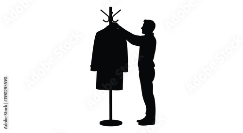 A silhouette of a man hanging a coat on a freestanding coat rack