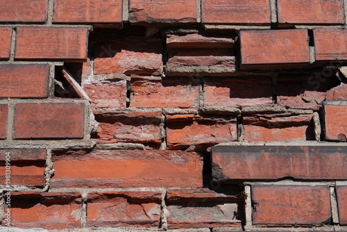 Damaged Red Brick Wall Texture with Broken Masonry and Decay