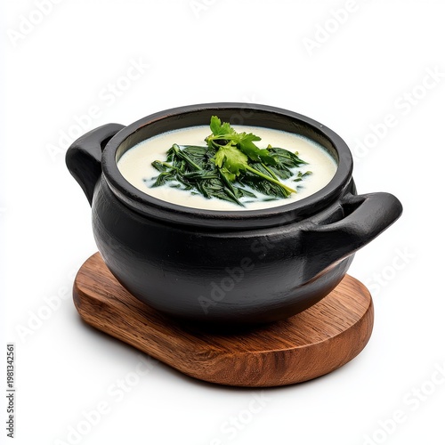 Traditional Indian Spinach Saag Curry in a Black Earthen Pot Served on Wooden Board with Fresh Green Herbs for Healthy Vegetarian Meal