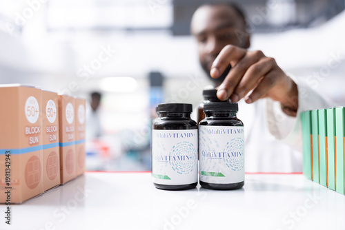 Photos Black male pharmacist stocking medicine and checking pill supplies at the pharmacy shop, ensuring proper arrangement and packaging of health products for safe storage and easy access