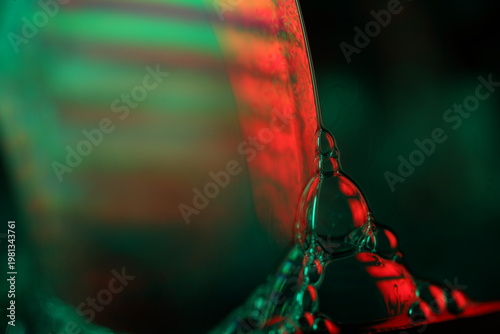 Abstract Macro Photography of Iridescent Fluid Bubbles with Vibrant Red and Green Light Refraction.