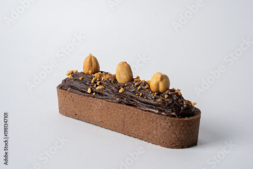 Quadro em tela A decadent tarte topped with rich chocolate and crunchy hazelnuts, featuring a buttery, flaky crust and smooth, indulgent filling, perfect for dessert lovers