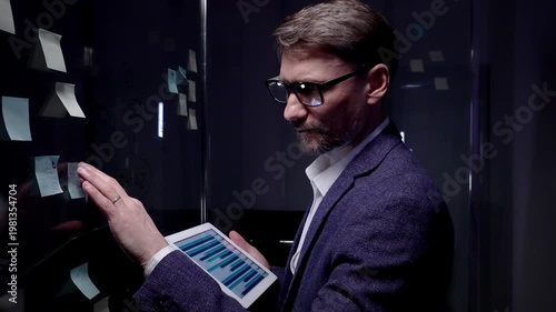 Businessman analyzing data on a digital tablet, managing business strategy, developing new ideas, brainstorming solutions, and planning project execution in a modern office