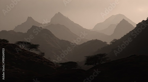 Layered rugged mountain ranges fade into atmospheric haze during twilight