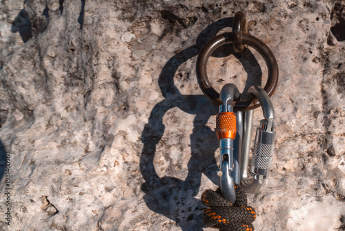 Climbing gear, carabiners, rope and anchor in  a rocky mountain closeup.