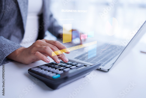 Business person using a calculator and laptop with stacking gold coins while analyzing a financial growth chart digital icons, analyzing finances and investment managing banking online.
