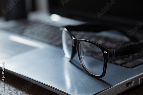 Business research, education, job closeup concept in different light with same camera manual, composition. Glasses on notebook keyboard. No people, nobody. Creative neutral lighting on blur background