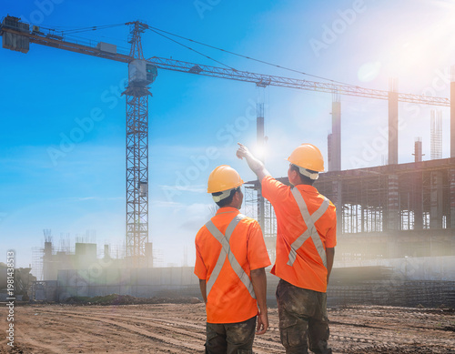Two Construction Workers Walk on Site with Bright Safety Vests