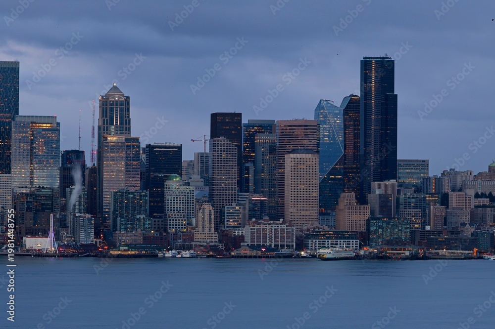Fototapeta premium The skyline of Seattle glows above the chilly waters of the Puget Sound