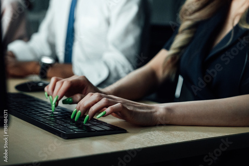 Φωτογραφία Southeast Asian woman creating digital design on computer with green fingernails at wooden desk, collaborating with a black shirt, focused work concept in a professional office setting