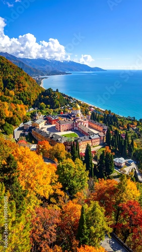 Aerial view of a coastal town surrounded by vibrant autumn foliage and mountains