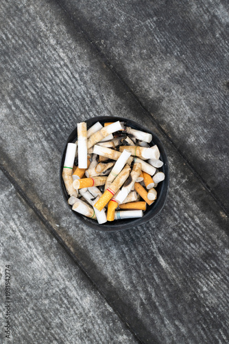 Konstfotografi Top view of used cigarette butts in ashtray on rough surface highlighting smokin