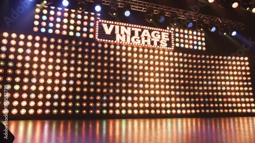 A lit stage with a vintage sign
