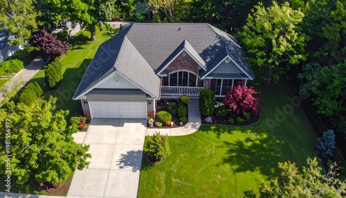Aerial view of a well-maintained suburban house with lush green landscaping