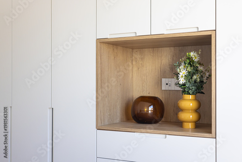 Photos Modern minimalist shelving unit with decorative vases and flowers in wooden nich