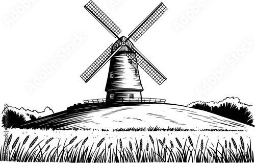 Vintage black and white of a traditional windmill a grassy hilltop with wheat field