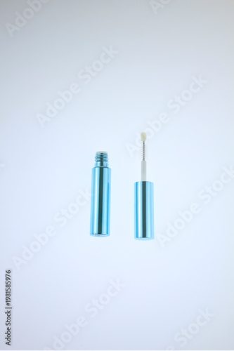 Minimalist cosmetic container blue tube with attached brush. Clean background enhances product's sleek design. Ideal for beauty, skincare, beauty cosmetic branding, isolated on white background. 