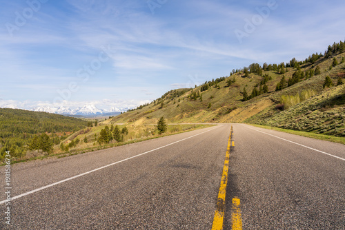 Empty Winding Road Leading Toward Grand Teton Mountains in Wyoming