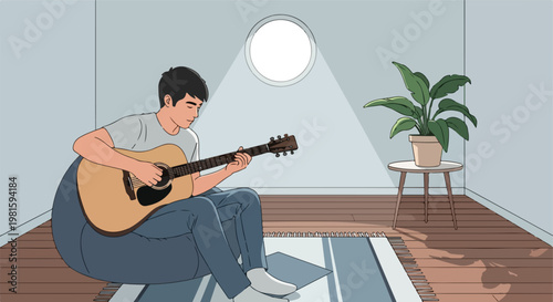 A young man plays acoustic guitar while sitting on a beanbag in a sunlit studio